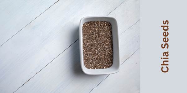 Dark brown chia seeds in a white rectangle bowl..