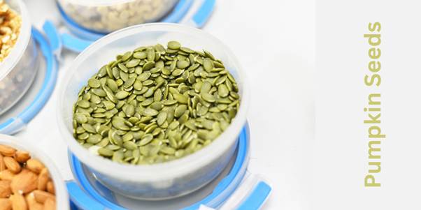 green colored pumpkin seeds in a white bowl